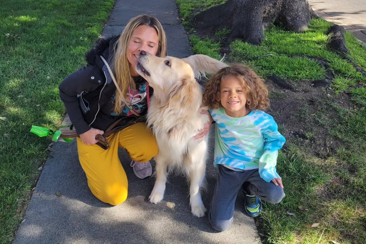 A woman, a child and a dog posing for a photo